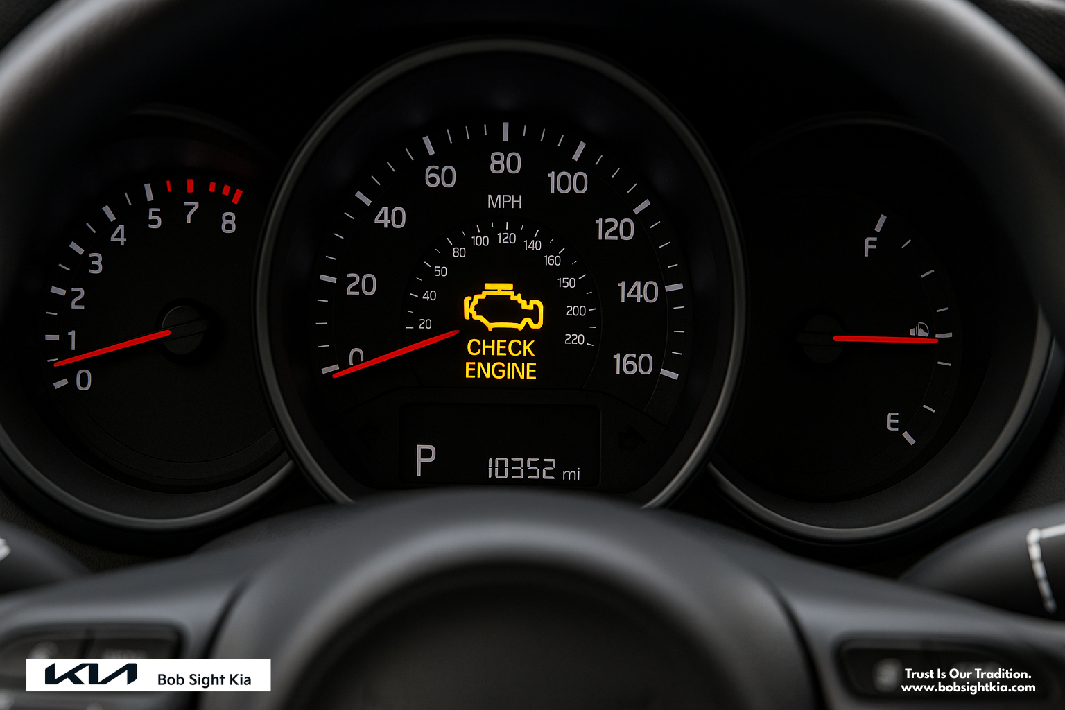 Close-up of a check engine light illuminated on a Kia dashboard, taken at Bob Sight Kia in Independence, Missouri